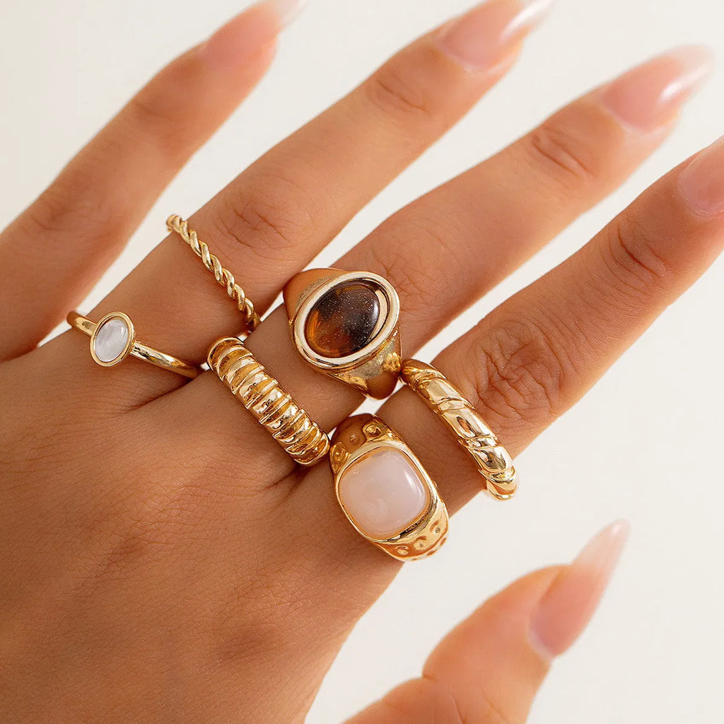 Six irregular geometric alloy rings in light gold electroplated finish arranged as set