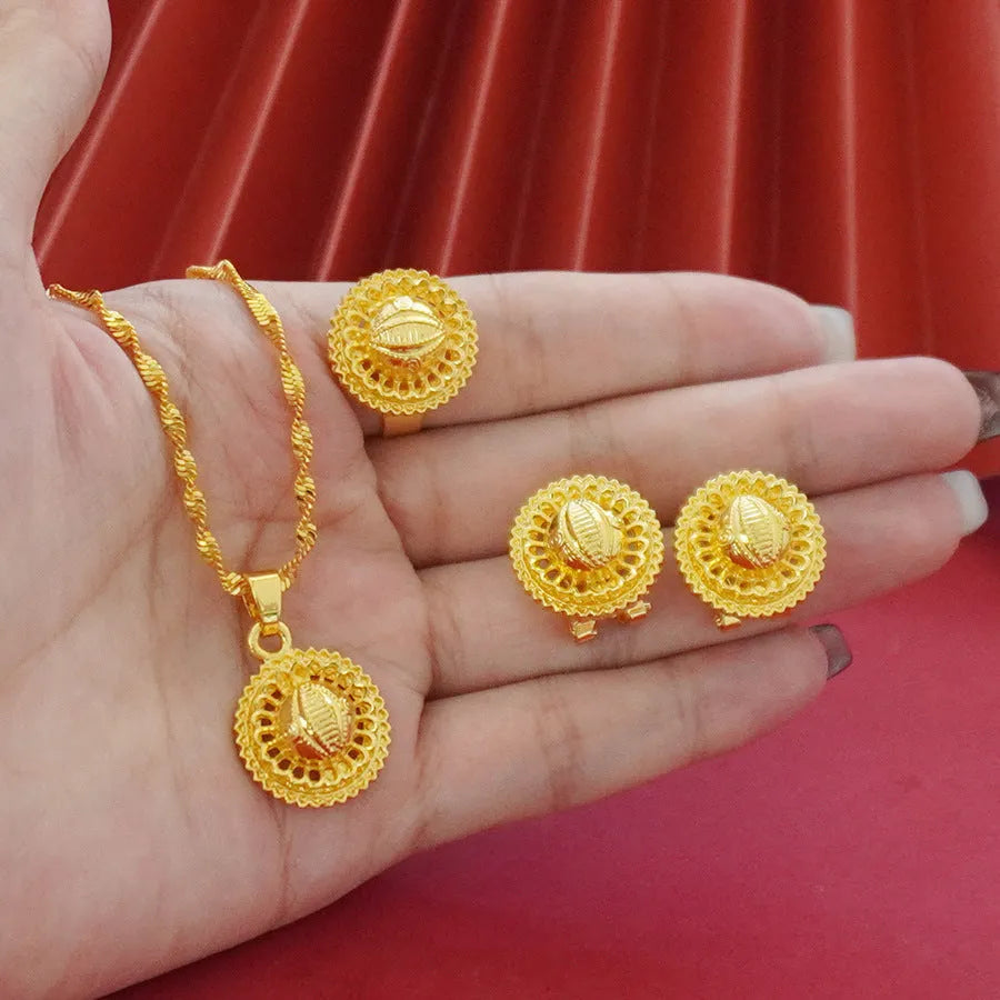 Gold-plated three-piece jewellery set showing necklace with floral pendant, matching earrings, and ring on a water wave chain.