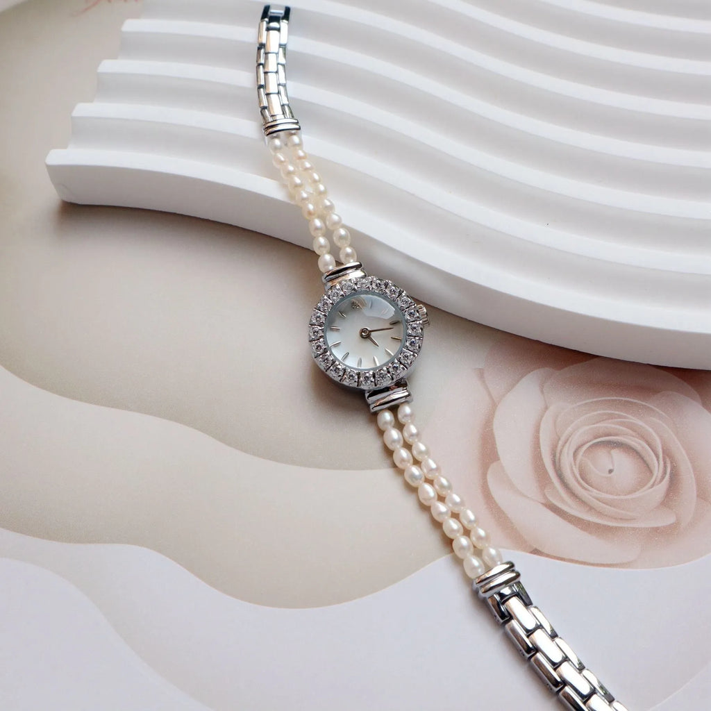 Women's light gold bracelet watch with freshwater pearls and an 18mm round dial.