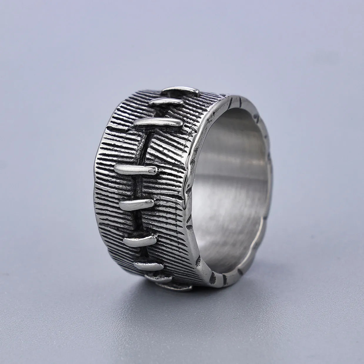 Titanium steel geometric U-shaped double ring with stitched texture in a retro colour.