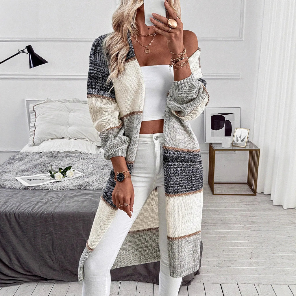 Grey loose fit women's knitted cardigan with long sleeves on a hanger.