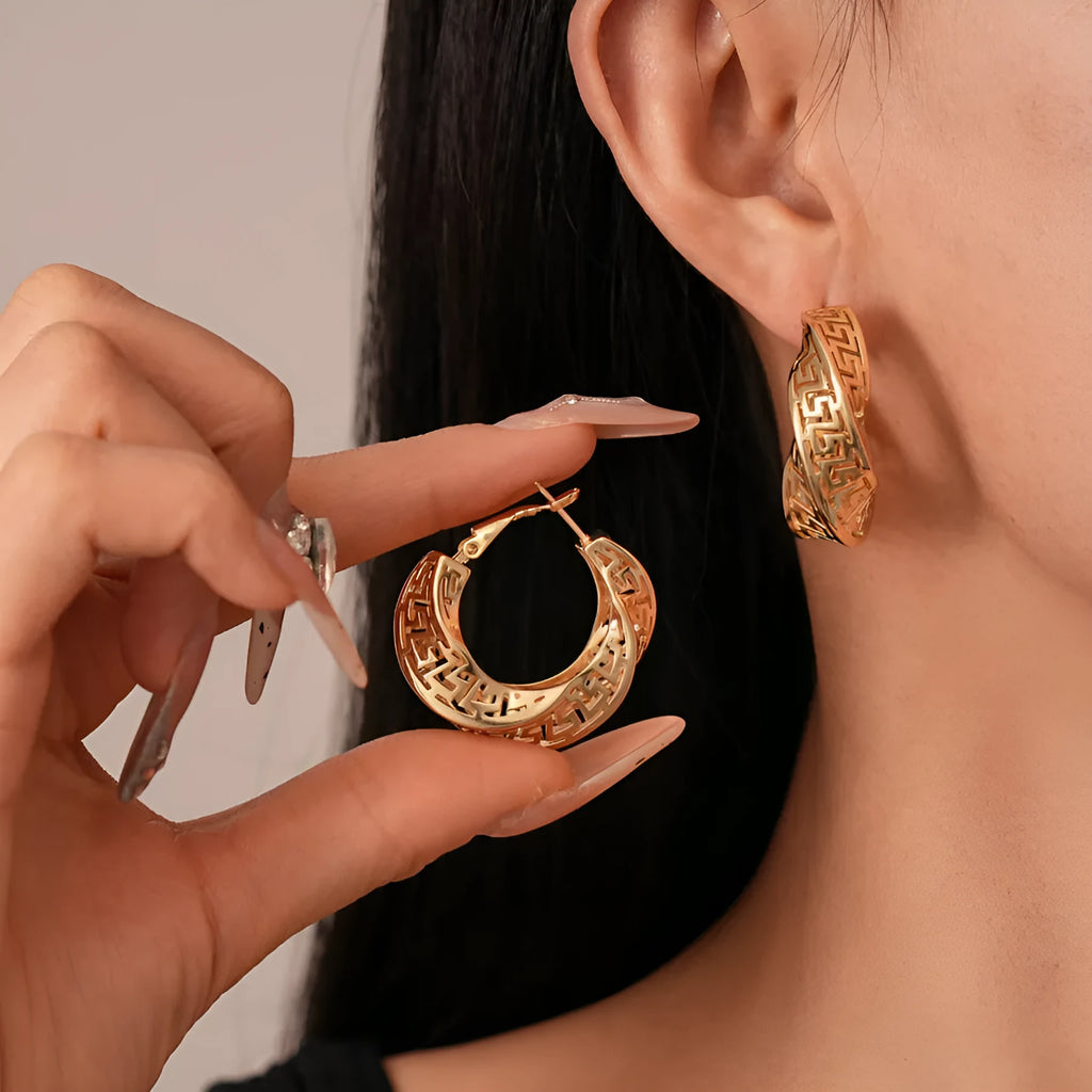 A pair of silver geometric women's stud earrings with a twisted round hollow design.