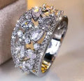Women's hollow round fashion ring in gold tone with blue stones, showing openwork design.