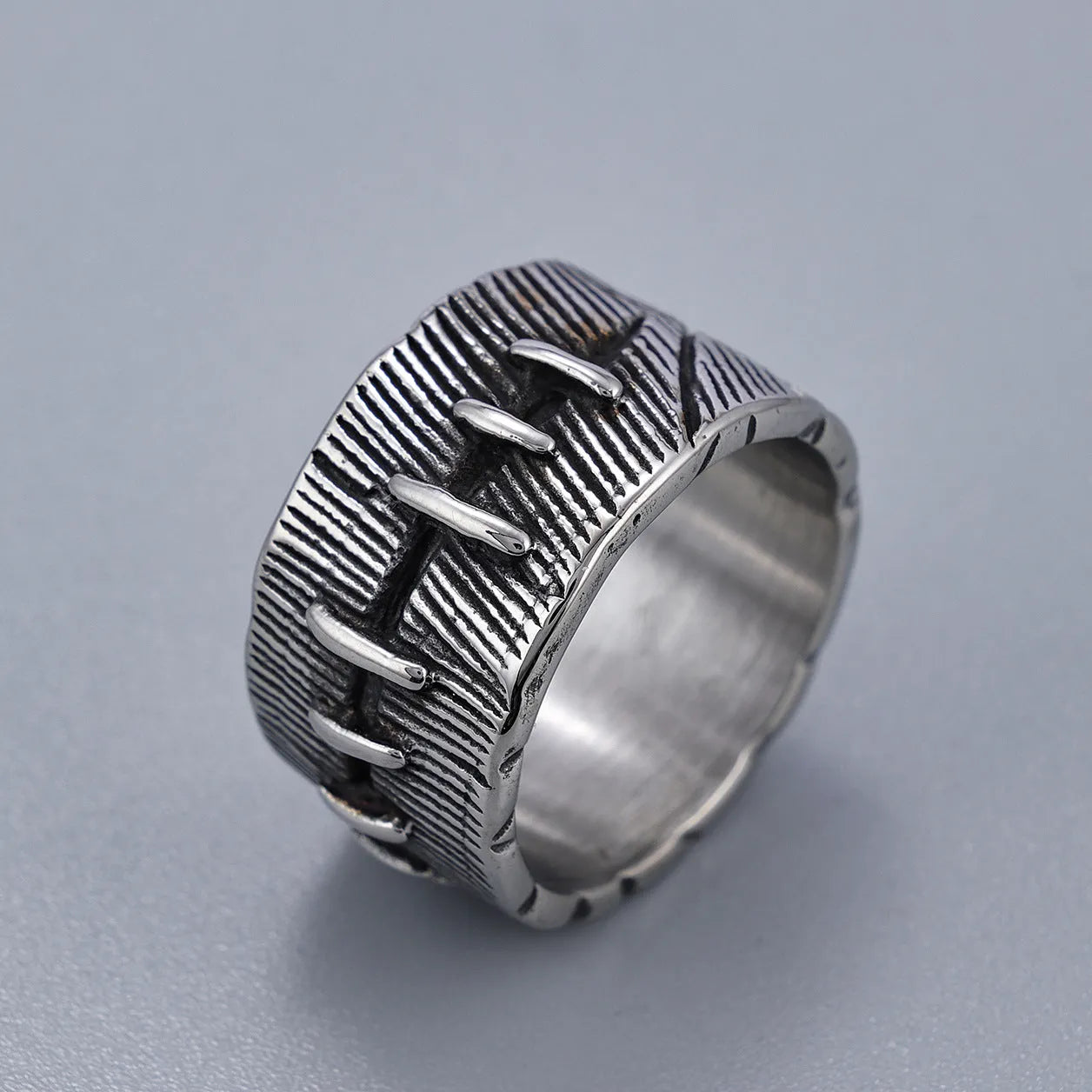 Titanium steel geometric U-shaped double ring with stitched texture in a retro colour.