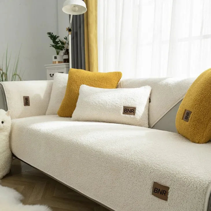 Solid colour lambswool sofa cover on a couch, showing cloth liner and neat fit.