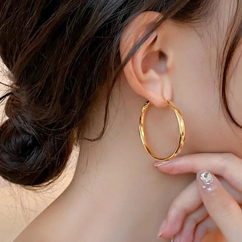 A pair of round gold-coloured metal hoop earrings on a 40mm diameter circle.