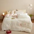 Winter milk fibre four-piece bedding set with green Christmas tree pattern on bed