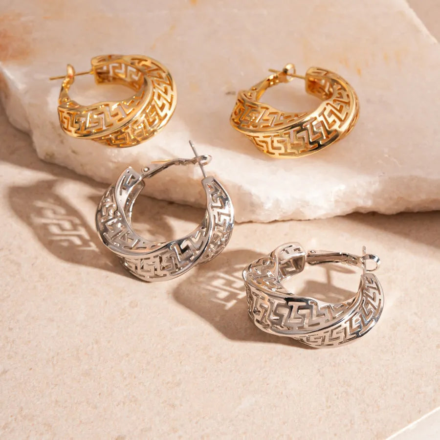 A pair of silver geometric women's stud earrings with a twisted round hollow design.
