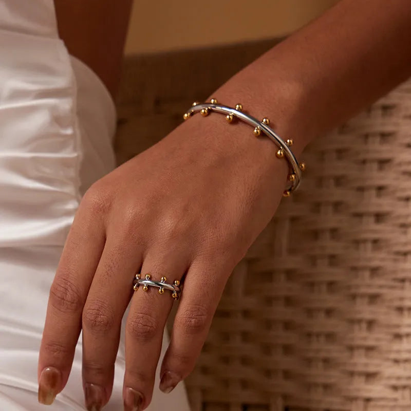 Stainless steel C-shaped bracelet with rivet bead texture in gold steel colour option