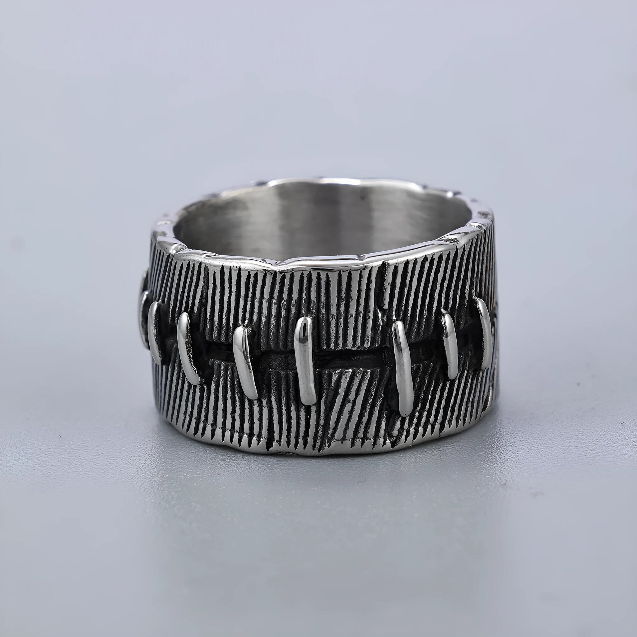 Titanium steel geometric U-shaped double ring with stitched texture in a retro colour.