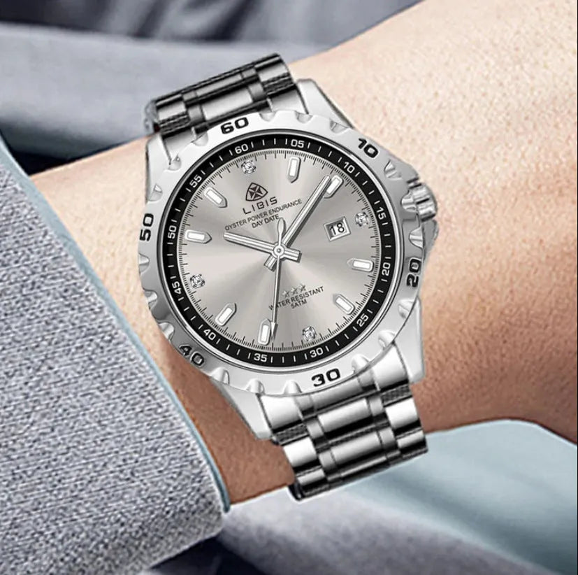 Silver case men's quartz watch with luminous hands and stainless steel bracelet on wrist