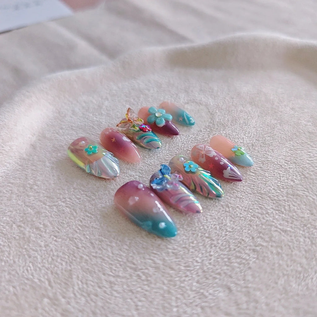 Handmade 3D nail art sculpture of embossed flowers and butterflies on an almond-shaped base.