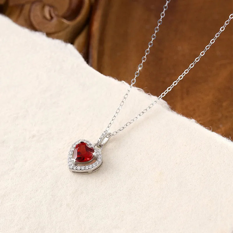 Sterling silver heart necklace with a natural amethyst gemstone on a cross chain.