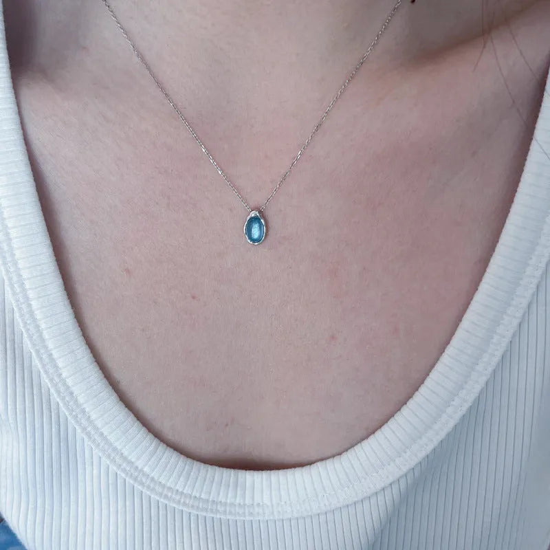 Navy blue geometric water drop necklace on adjustable cross chain, platinum-colour finish