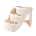 Foldable grey plastic pet stairs for small dogs and cats next to a sofa.