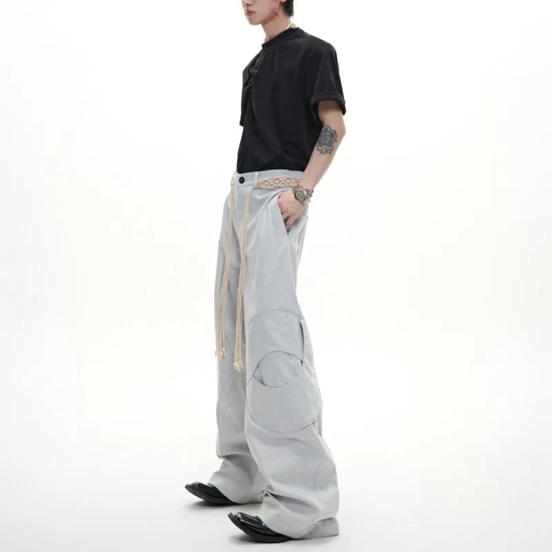 Man wearing dark blue straight leg jeans with belt stitching and decorative details