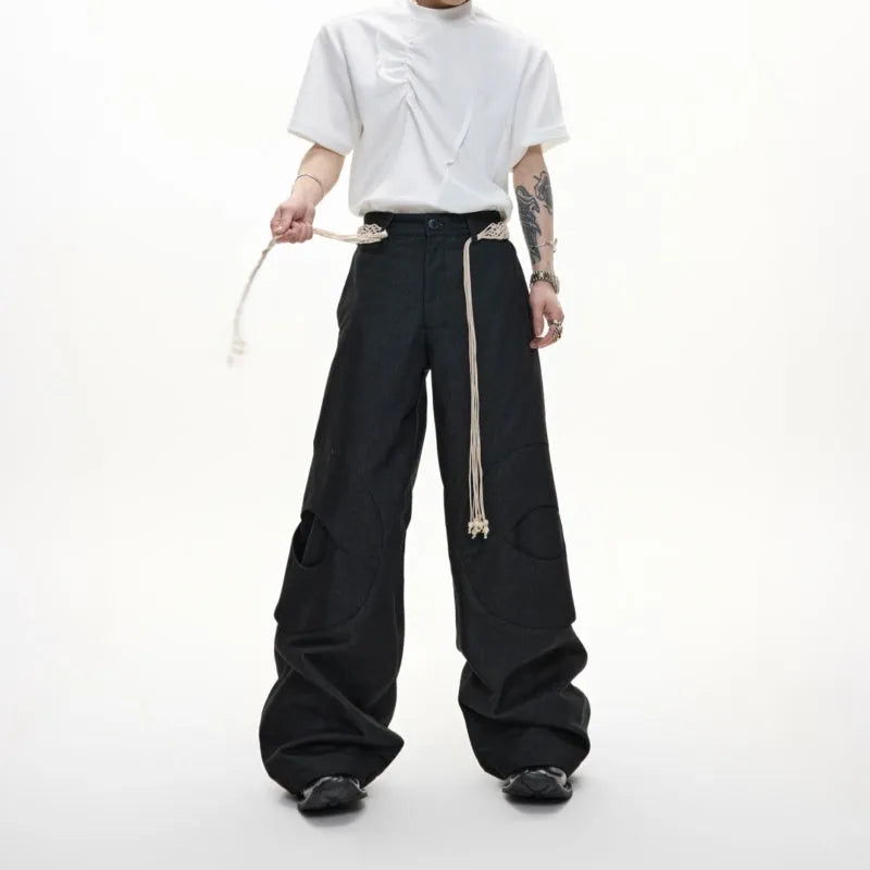 Man wearing dark blue straight leg jeans with belt stitching and decorative details