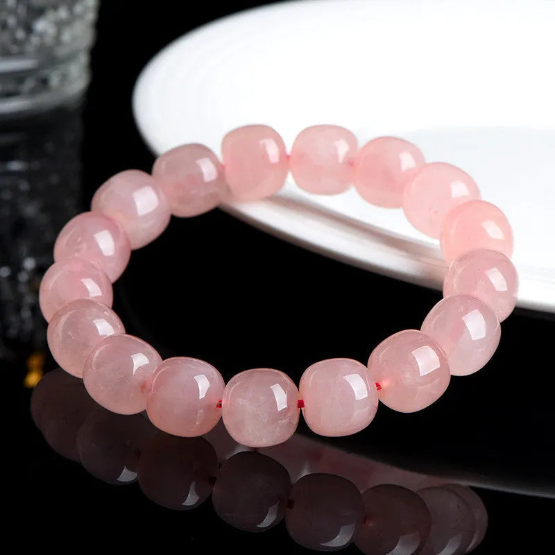 Pink natural crystal bracelet with barrel-shaped beads measuring 8 to 10 mm.