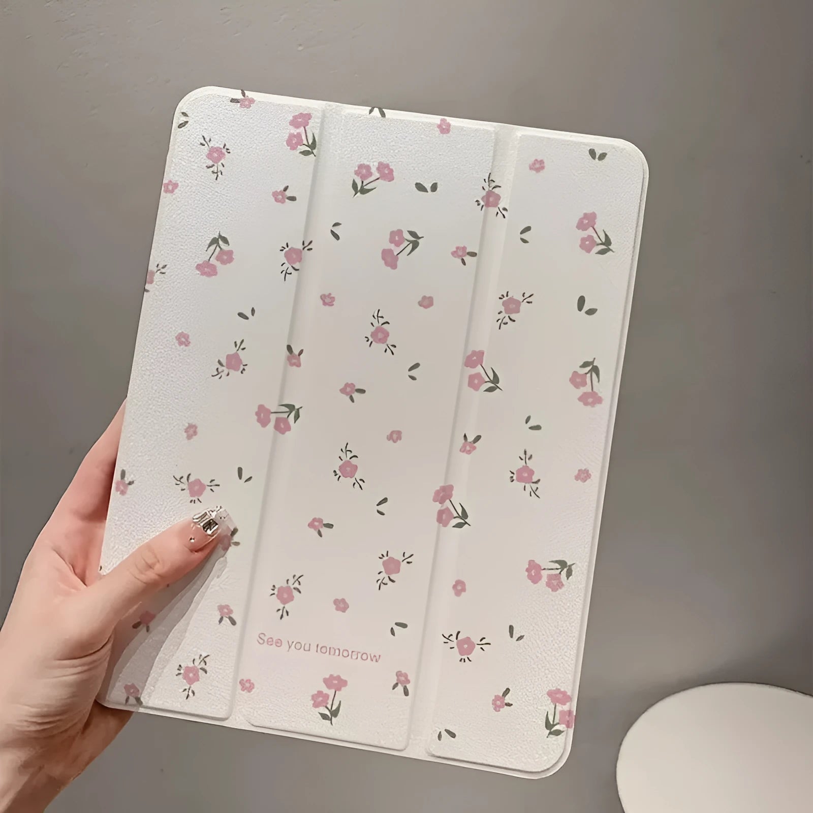 Transparent floral tri-fold iPad protective case showing magnetic stand functionality for Apple tablet models
