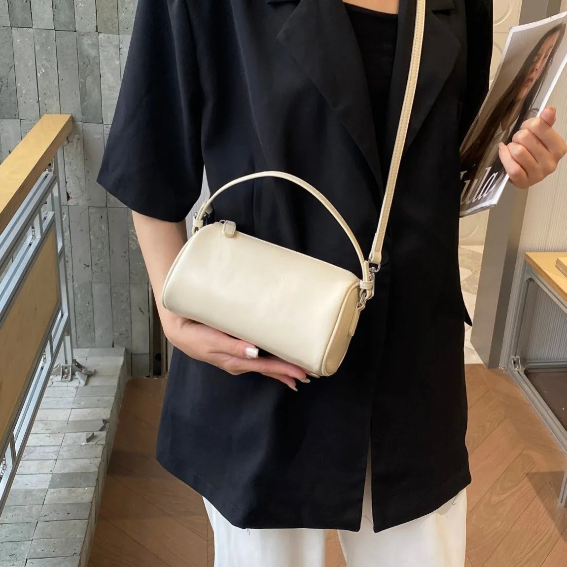 Vegetable tanned leather crossbody phone bag in cylindrical shape on a single adjustable strap.