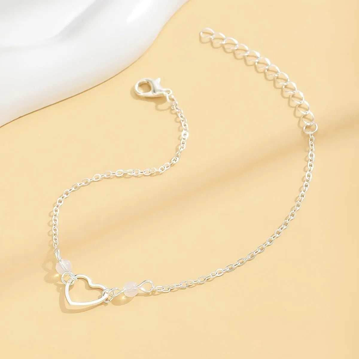Adjustable women's anklet with heart-shaped geometric pendant in gold or silver alloy metal