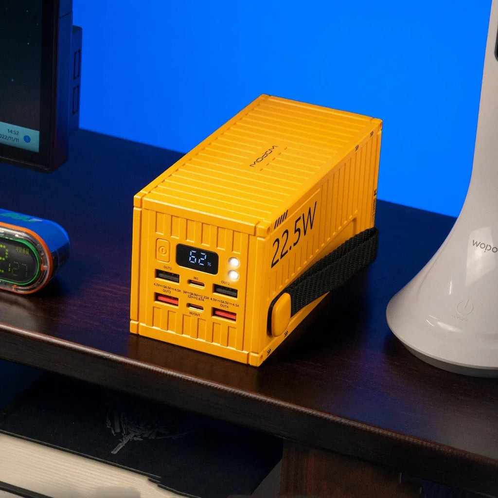 Large yellow 50000mAh power bank with digital display showing battery percentage and multiple USB ports.