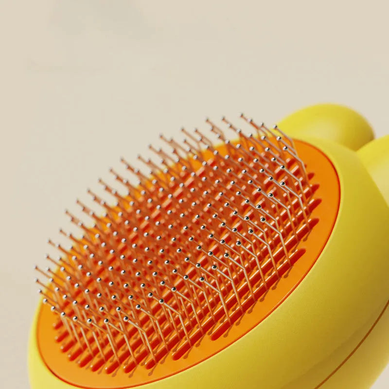Green pet grooming brush with a release button and stainless steel teeth on a non-slip handle.