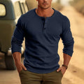 Man wearing a navy blue long-sleeved t-shirt with a henry collar, showcasing the European cut and cotton blend fabric.