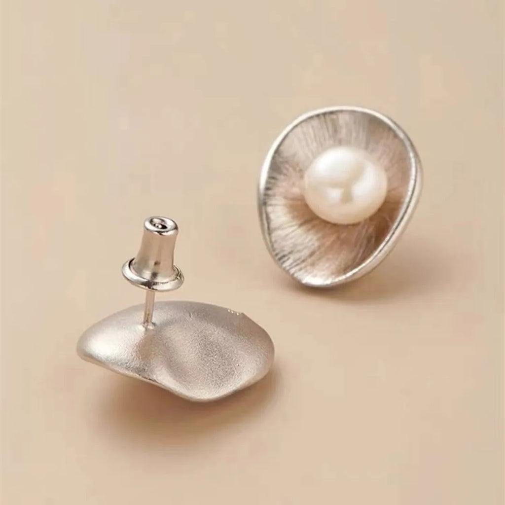 A pair of gold-coloured geometric sterling silver ear studs featuring pearl accents.