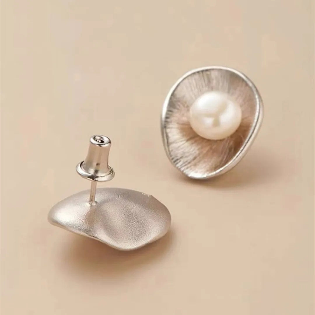 A pair of gold-coloured geometric sterling silver ear studs featuring pearl accents.
