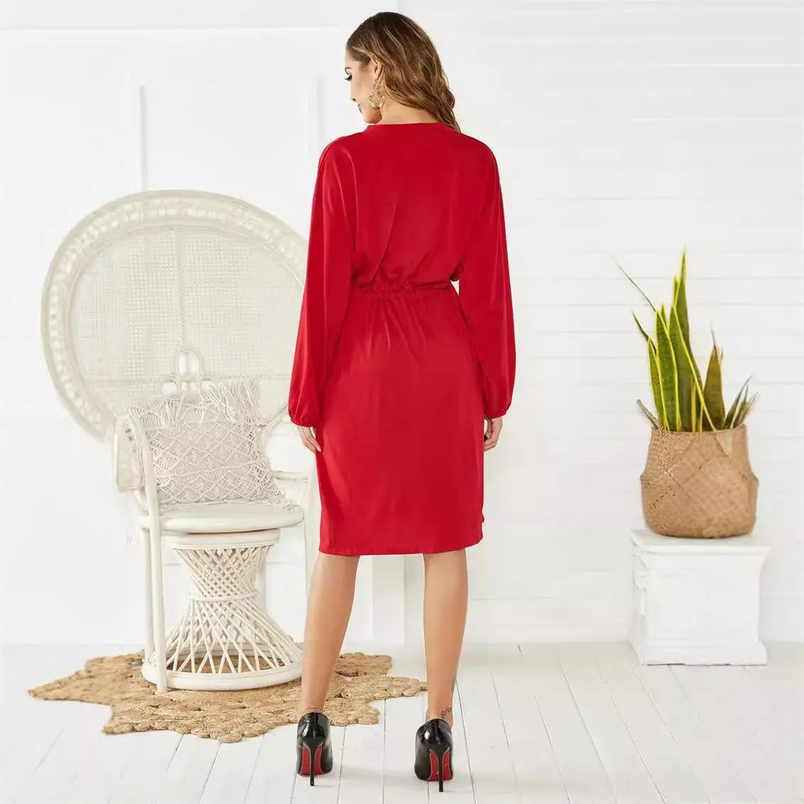 Black women's A-line midi dress with long sleeves, elastic waist, cuffs, and a matching belt.