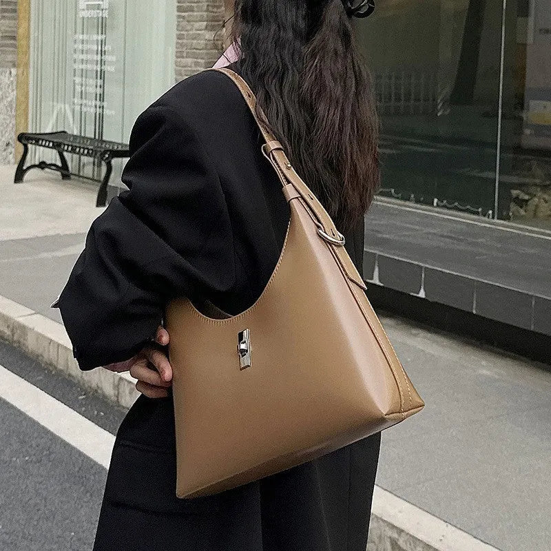Women's soft genuine leather crossbody shoulder bag in a dumpling shape, shown in a light colour.
