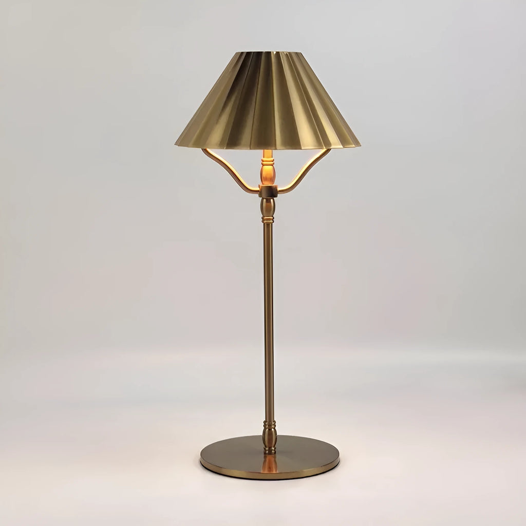 Gold alloy desk lamp with a fabric lampshade on a wooden table