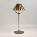 Gold alloy desk lamp with a fabric lampshade on a wooden table
