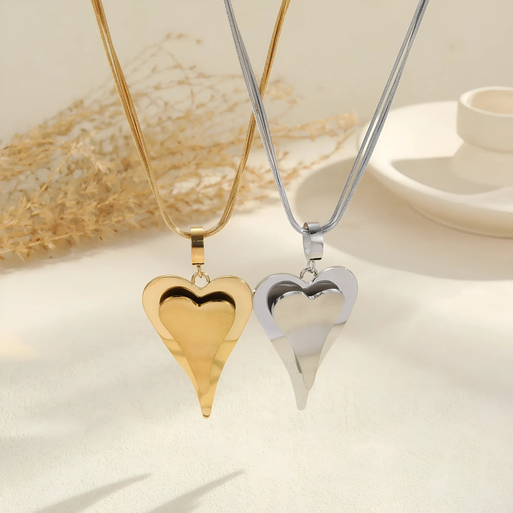 Women's stainless steel necklace with double heart geometric pendant on a snake bones chain in gold or steel finish.