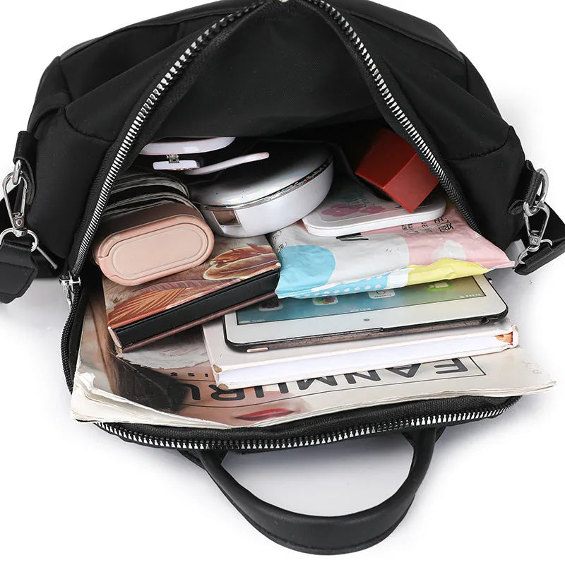 Large black PU backpack with a three-dimensional pocket, shown open to reveal internal phone pocket.