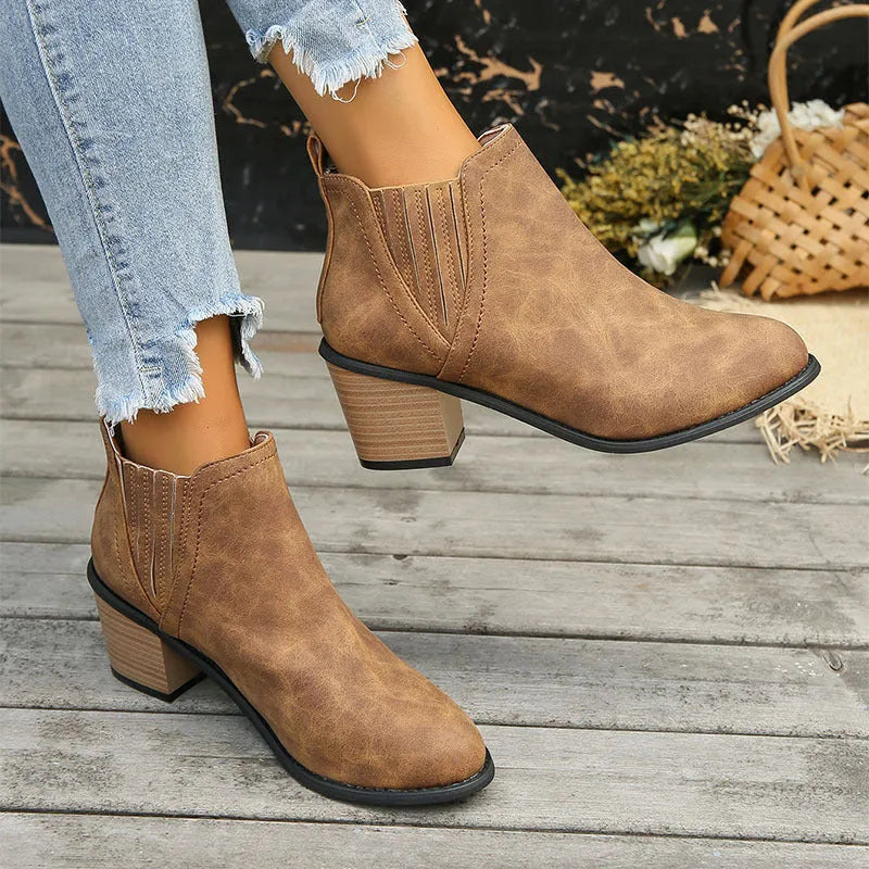 Women's black pointed toe ankle boots with a thick square low heel and slip-on design.