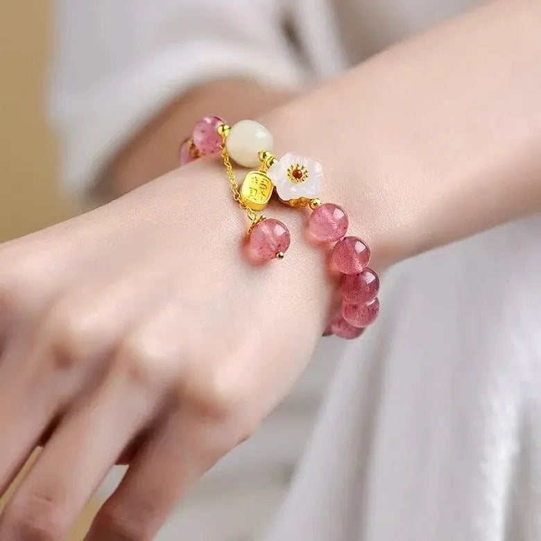 Handcrafted strawberry quartz and Hetian jade bracelet with peach blossom charm for girls.