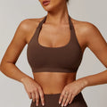 Women's black halter neck sports bra with medium support and built-in chest pads.