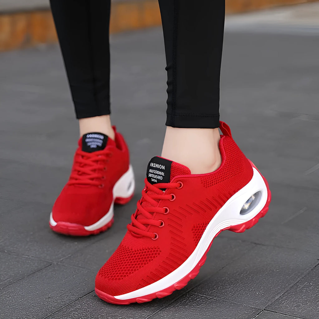 Women's red low-top lace-up mesh sneakers with round toe and a visible mid-height sole.