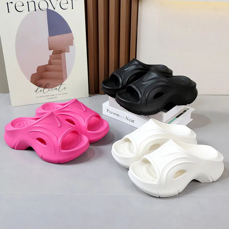 Women's thick-soled EVA slippers in rose red colour on a sandy beach background.
