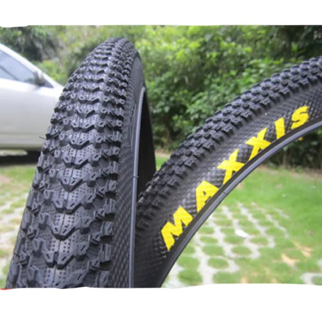 Ultralight black mountain bike tyre with white label sidewall option on a trail.