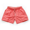 Men's straight leg beach shorts in polyester, shown in multiple colours including fluorescent yellow and navy blue.