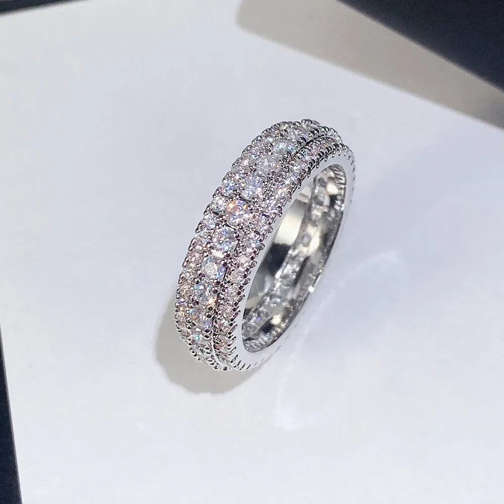 Geometric triangular unisex ring with a central zircon stone, shown in white gold, yellow gold, and white and black plating options.