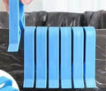 Transparent plastic non-slip clip for holding a garbage bag on the rim of a bin.