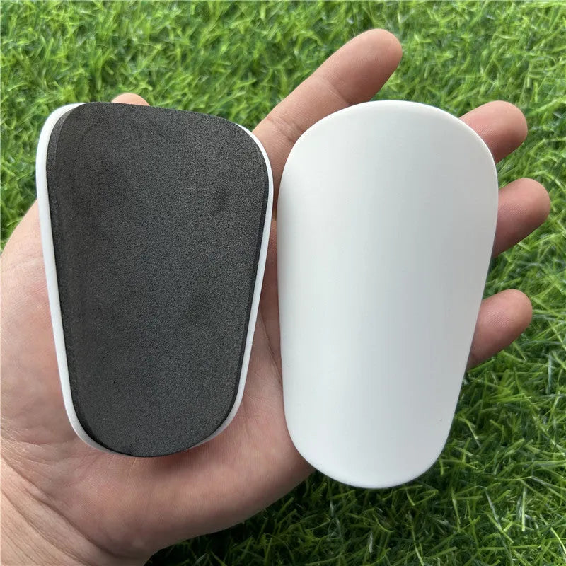 Extra small plastic football shin guards measuring 8x5cm in black and white for youth players