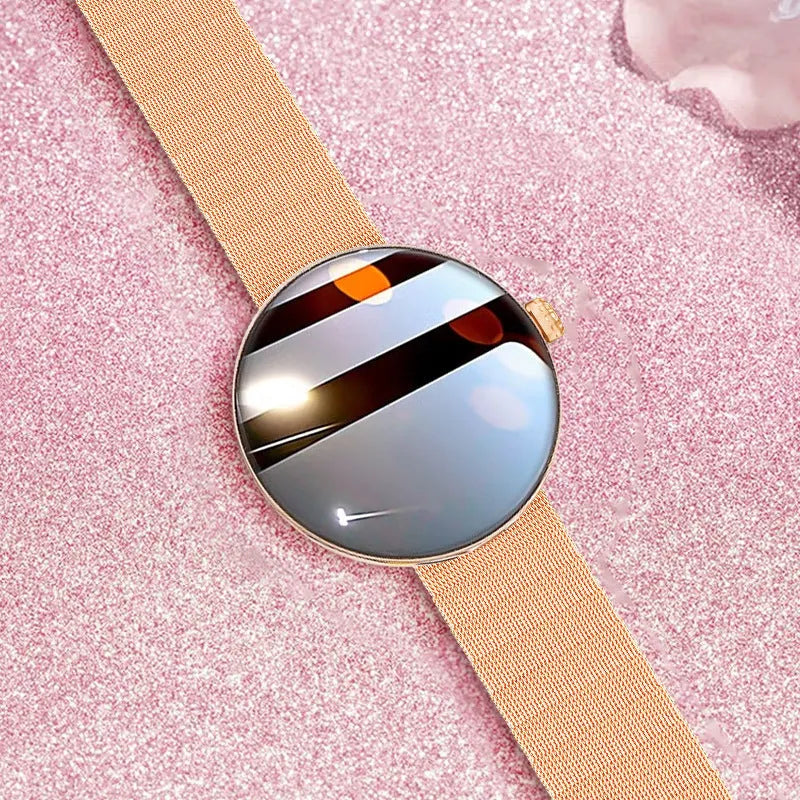 Circular women's smartwatch with metal strap and colour touchscreen display on a wrist.