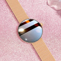 Circular women's smartwatch with metal strap and colour touchscreen display on a wrist.