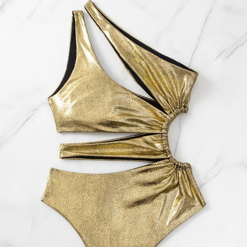 Gold one-piece backless swimsuit for women laid flat, showing sleeveless design.