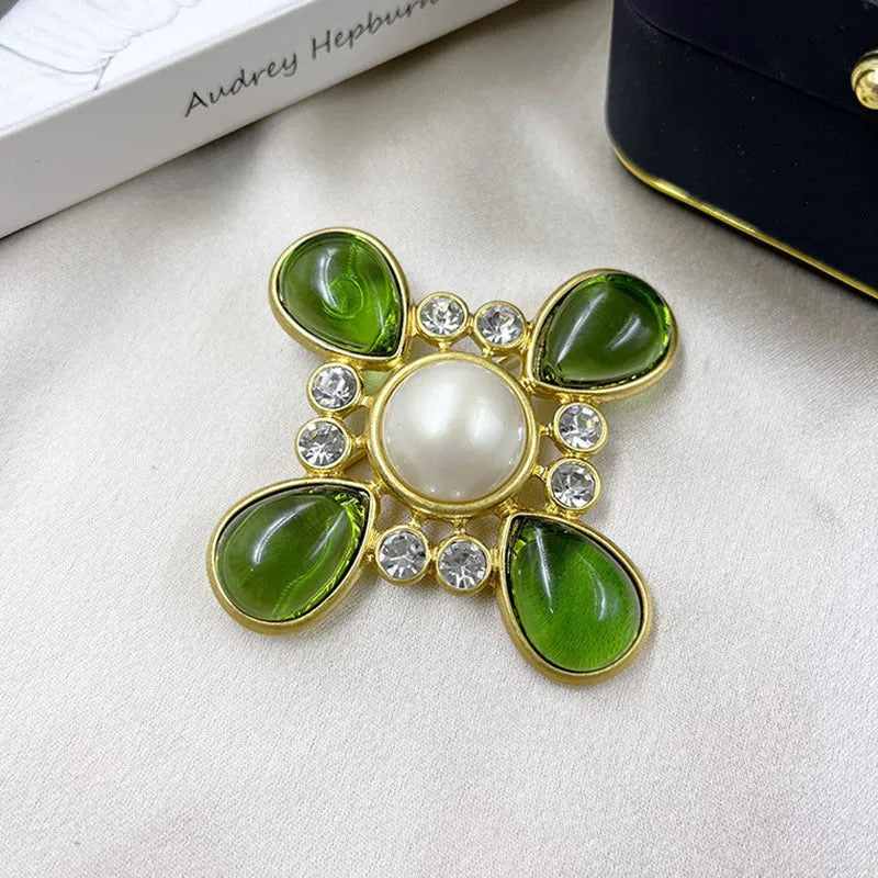 Close-up of a zinc alloy baroque brooch with a central crystal cross in a vintage style.